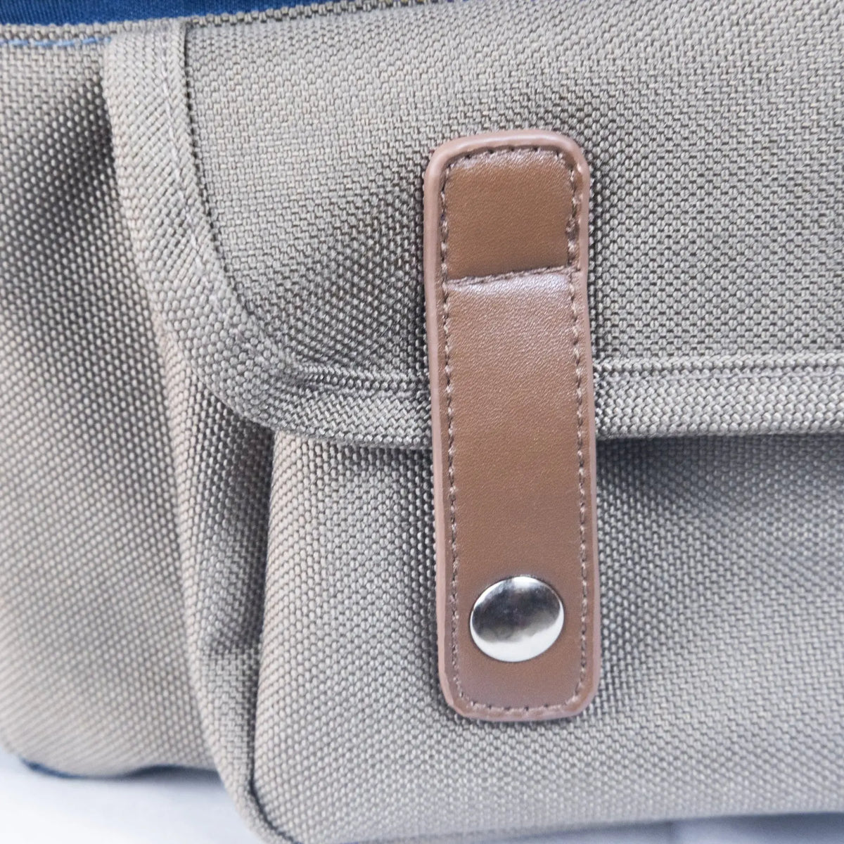 Pochette en cuir à bouton-pression sur un sac à dos pour chien, un rangement élégant pour l’équipement de plein air.