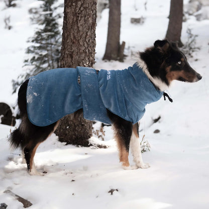 Veste polaire pour chien avec sangles réglables, offrant isolation et confort pour explorer les paysages hivernaux.